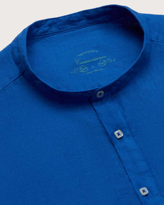 Close-up of a blue shirt with collar and buttons on a light gray background